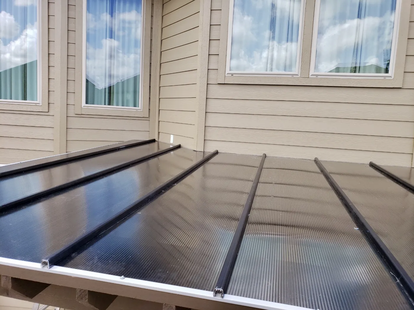 Close view of bronze Hercules polycarbonate panels and standing seams
