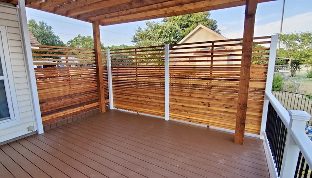 Trex deck with stained cedar pergola, privacy wall, and custom metal and painted wood railing