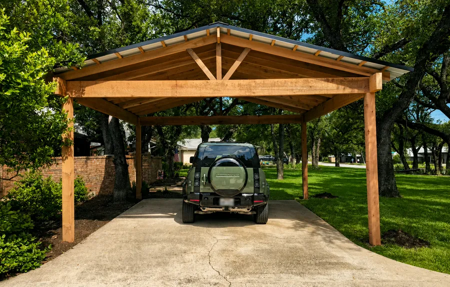 Pavilion-style gable-roof cedar carport with a 24-foot span for two full-size vehicles